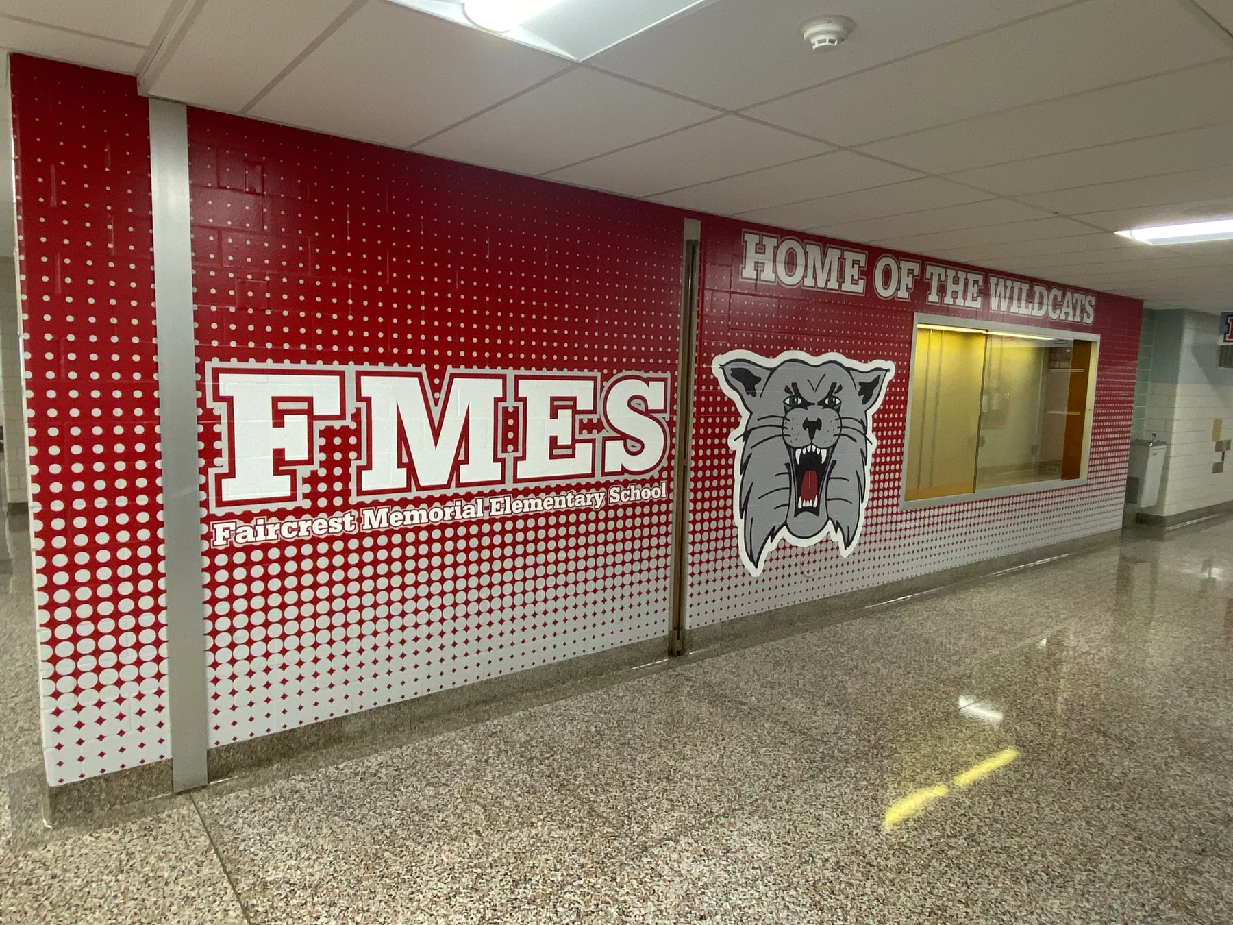 Red and white Faircrest Memorial Elementary School hallway wall graphics with Wildcats mascot and school lettering