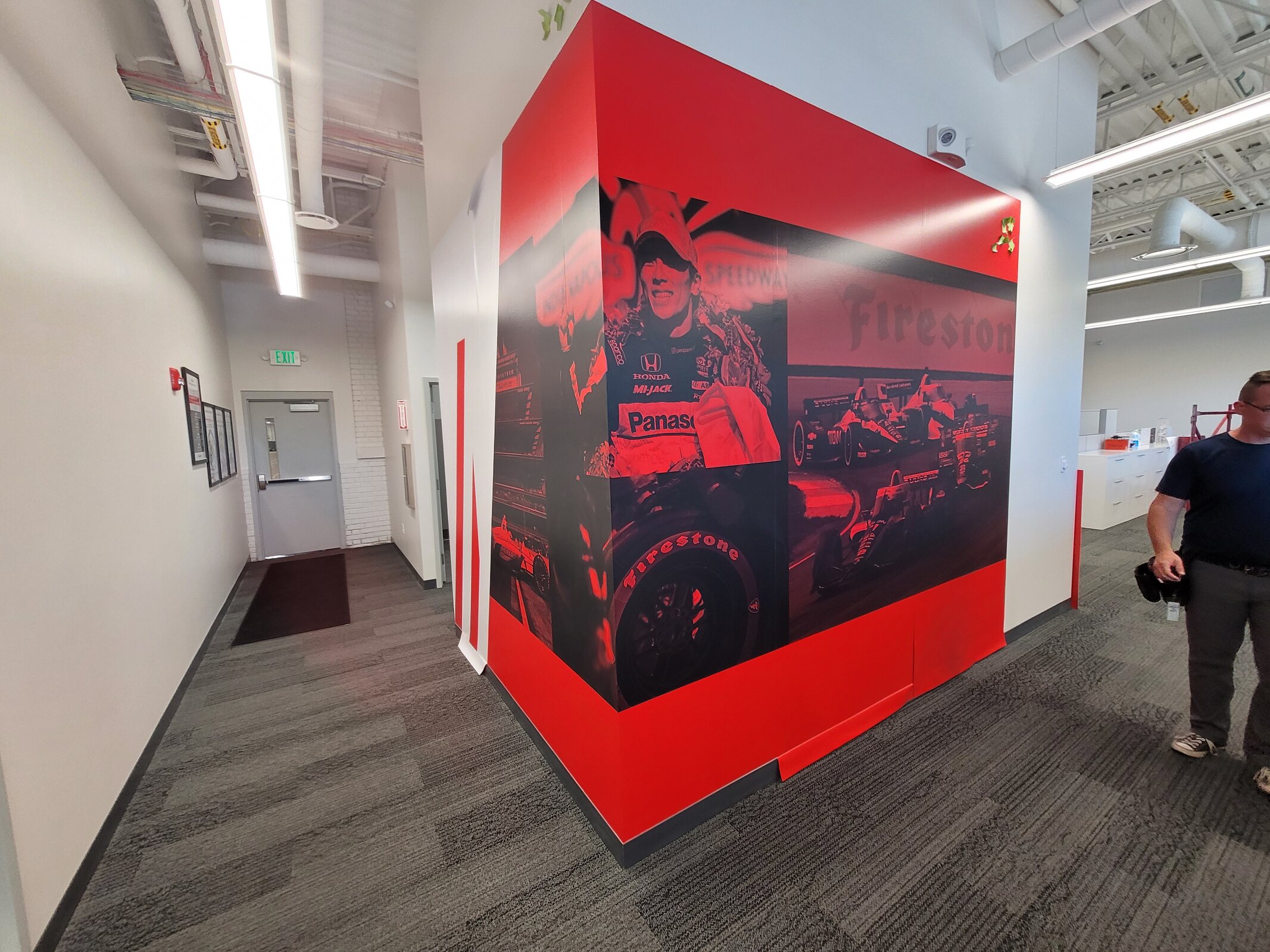 Red environmental wall graphic installed in a commercial corridor